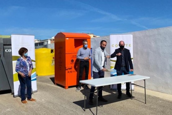 El president del COPATE i el gerent de la Fundació Formació i Treball amb mascareta davant d'un contenidor de donació de roba